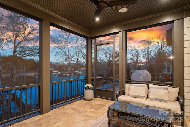 sunroom / solarium featuring a ceiling fan