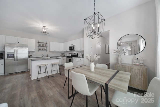 dining area with dark wood-type flooring, radiator, a chandelier, and sink