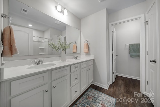 bathroom featuring vanity, a shower, and hardwood / wood-style floors