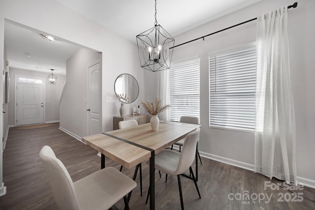 dining room with dark hardwood / wood-style flooring, a wealth of natural light, and an inviting chandelier