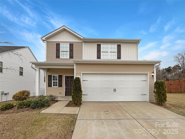 traditional home with a garage, concrete driveway, and a front yard