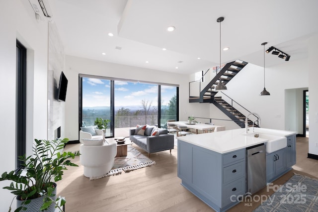 living area featuring light wood-type flooring, recessed lighting, and stairs