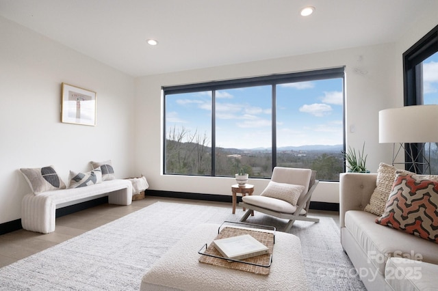 living area featuring baseboards, a mountain view, light wood-style flooring, and recessed lighting