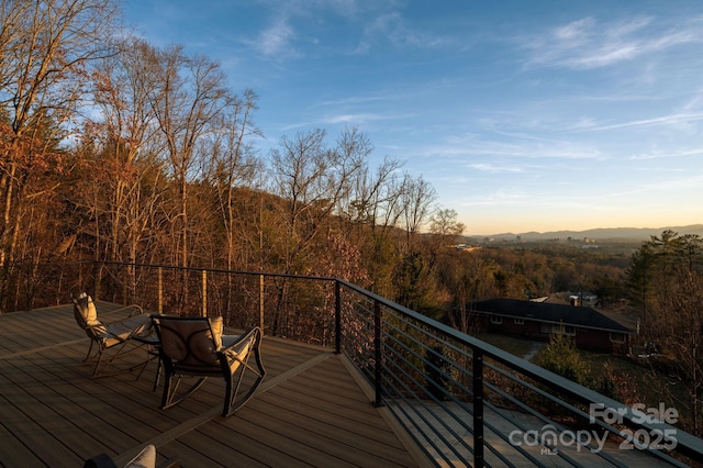 deck at dusk featuring a mountain view