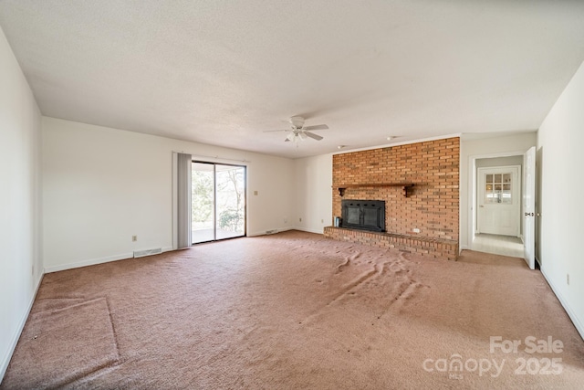 unfurnished living room with carpet floors, a fireplace, visible vents, a ceiling fan, and a textured ceiling