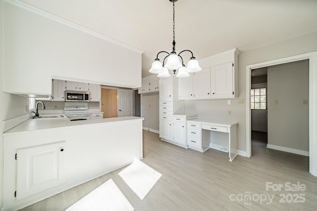 kitchen featuring a peninsula, a sink, white range with electric stovetop, light wood finished floors, and stainless steel microwave