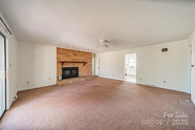 unfurnished living room with carpet floors, a wealth of natural light, a brick fireplace, and visible vents