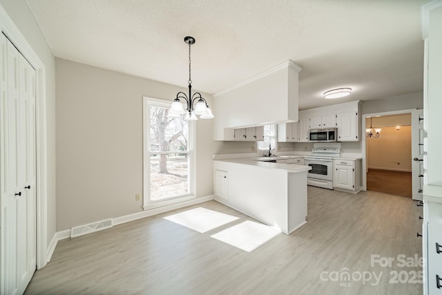 kitchen with electric stove, stainless steel microwave, visible vents, an inviting chandelier, and a sink