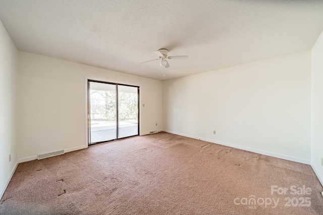 unfurnished room with visible vents, light carpet, ceiling fan, a textured ceiling, and baseboards