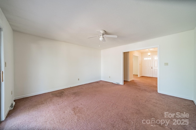 unfurnished room with visible vents, carpet floors, a ceiling fan, and baseboards