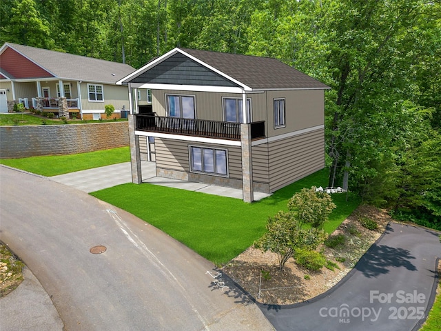 view of front of property featuring a balcony and a front lawn