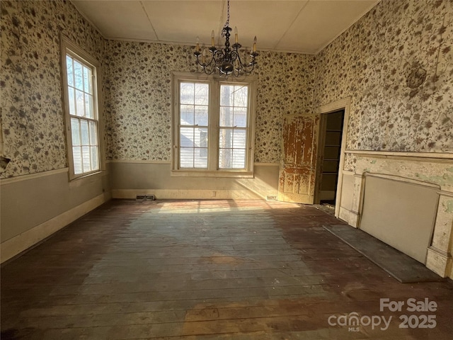 spare room with dark hardwood / wood-style flooring and a chandelier