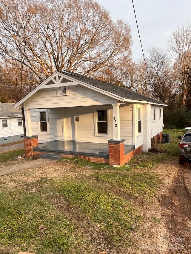 view of front of home featuring covered porch and a front lawn