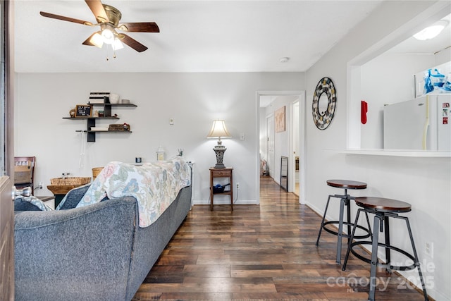 living room with ceiling fan and dark hardwood / wood-style flooring