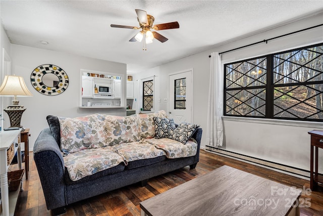 living room with ceiling fan, a baseboard radiator, dark hardwood / wood-style floors, and a textured ceiling