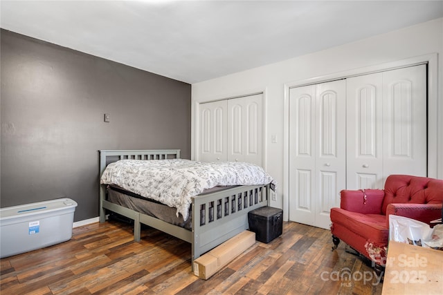 bedroom featuring two closets and dark wood-type flooring