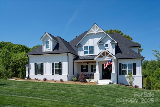 view of front of property featuring brick siding, a porch, board and batten siding, a ceiling fan, and a front lawn