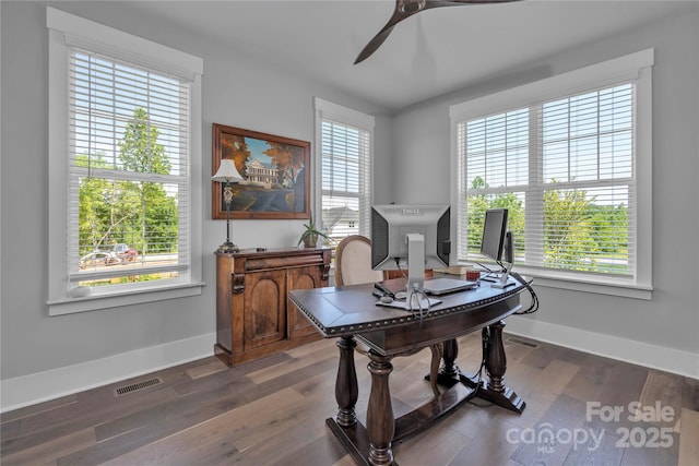 office area featuring a wealth of natural light, dark wood finished floors, visible vents, and a ceiling fan