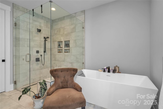 full bathroom with a sink, a stall shower, a freestanding tub, and recessed lighting