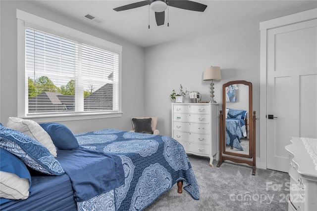 carpeted bedroom with ceiling fan and visible vents