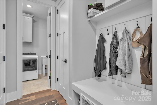 mudroom featuring dark wood-style floors, a sink, and washer / dryer