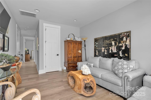 living room with recessed lighting, baseboards, visible vents, and light wood finished floors