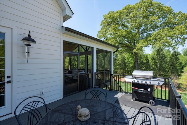 deck featuring outdoor dining area, grilling area, and a sunroom