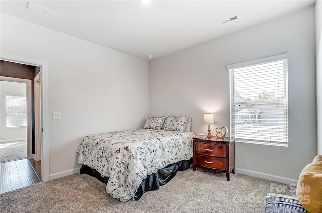 carpeted bedroom with visible vents and baseboards