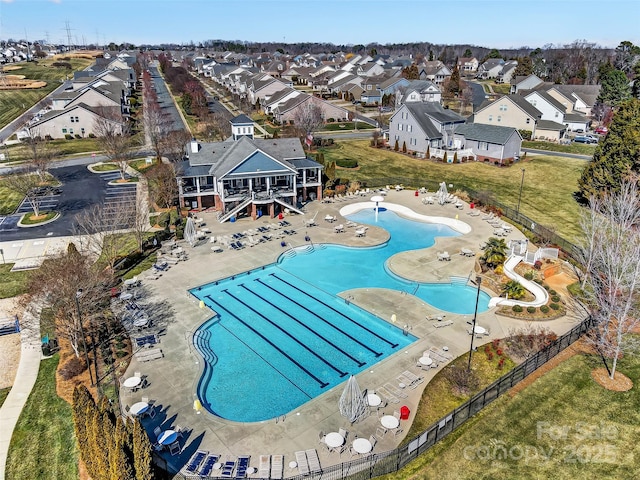 community pool featuring a residential view, fence, and a patio