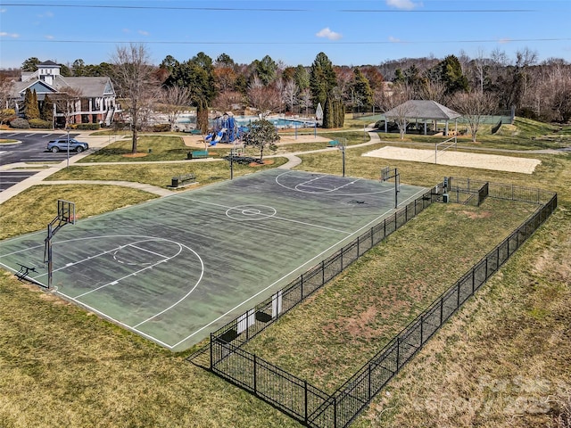 view of sport court with community basketball court, fence, and a lawn