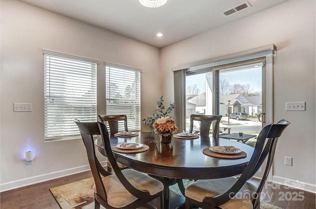 dining area with dark wood-style floors, a healthy amount of sunlight, and visible vents