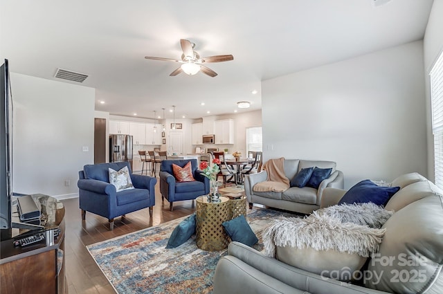 living room featuring recessed lighting, dark wood-type flooring, visible vents, baseboards, and a ceiling fan