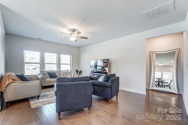 living room featuring ceiling fan, dark wood-style flooring, visible vents, and baseboards