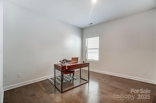 office space with visible vents, baseboards, and dark wood finished floors