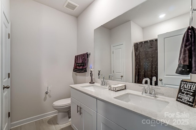 full bath with double vanity, baseboards, visible vents, and a sink