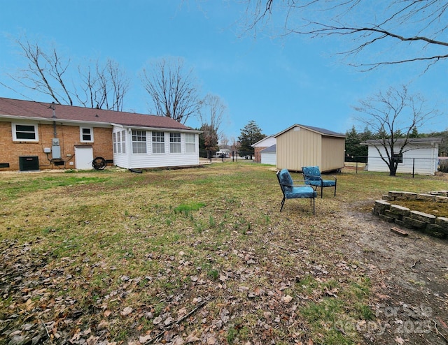 view of yard featuring a garage, an outdoor structure, and central AC