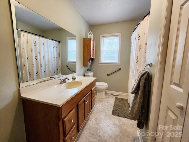 bathroom featuring vanity, a textured ceiling, and toilet