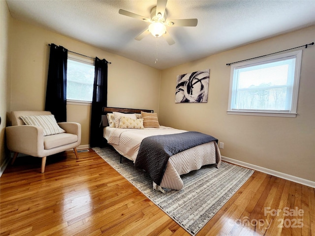 bedroom featuring hardwood / wood-style flooring, ceiling fan, and a textured ceiling