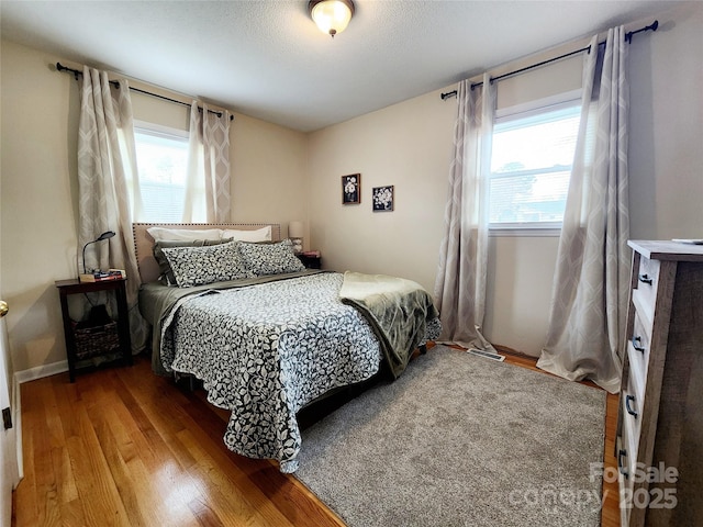 bedroom featuring multiple windows and hardwood / wood-style floors