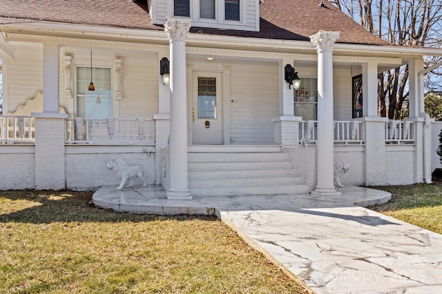 property entrance with covered porch, roof with shingles, and a lawn