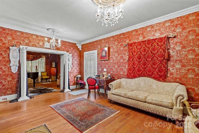 living room with an inviting chandelier, wallpapered walls, and wood finished floors