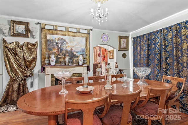 dining room featuring arched walkways, ornamental molding, and an inviting chandelier