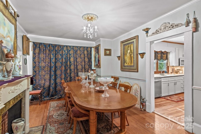 dining room featuring light wood-style floors, a chandelier, and crown molding