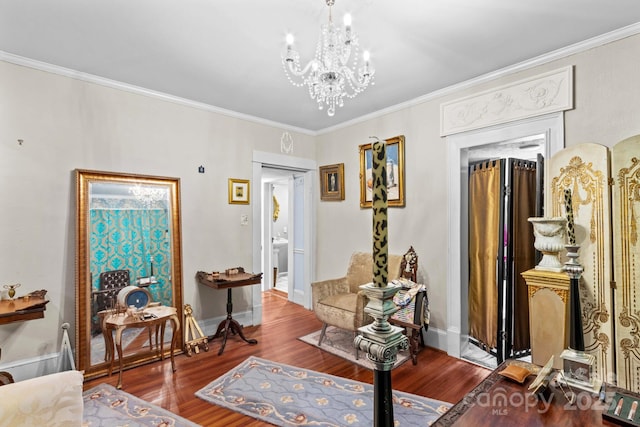 interior space featuring ornamental molding, a notable chandelier, baseboards, and wood finished floors