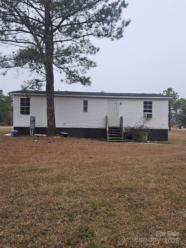 rear view of house featuring cooling unit and a lawn