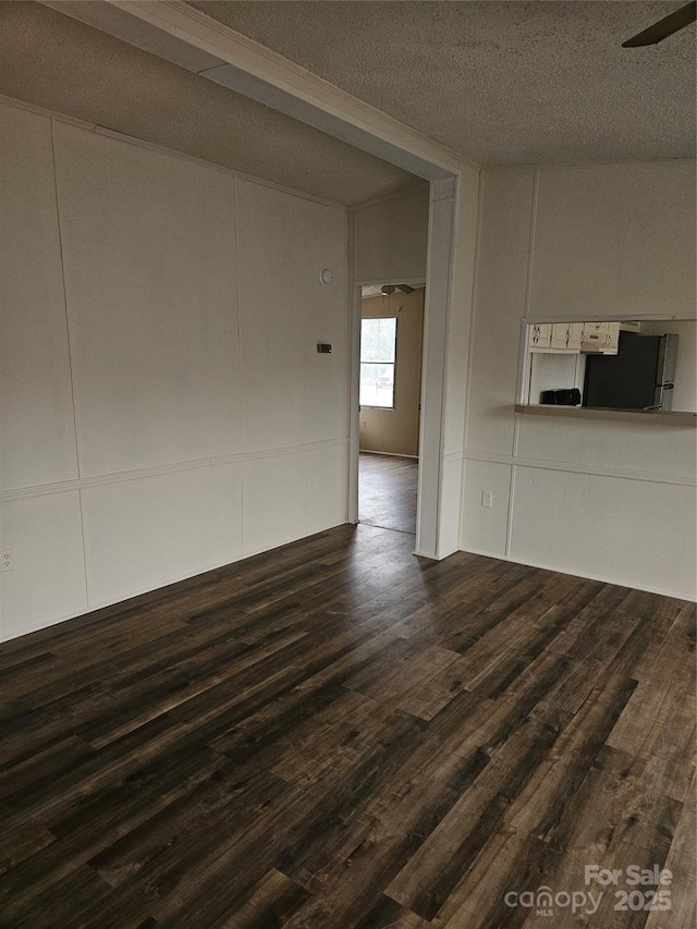 unfurnished living room featuring dark hardwood / wood-style floors and a textured ceiling