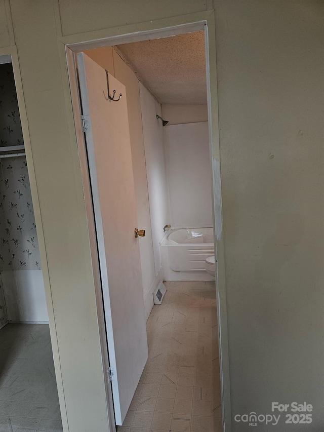 bathroom featuring wood-type flooring, toilet, and a textured ceiling