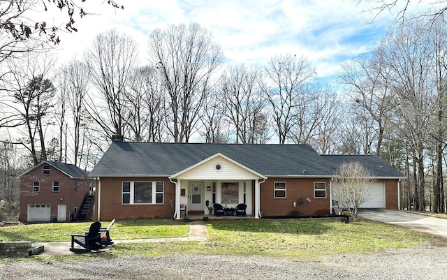 ranch-style house featuring a garage, a front yard, and a porch