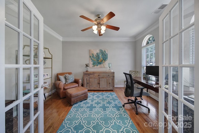 home office with light wood-type flooring, french doors, crown molding, and ceiling fan