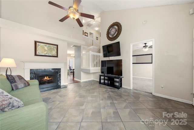 unfurnished living room featuring ceiling fan, tile patterned floors, a fireplace, and high vaulted ceiling